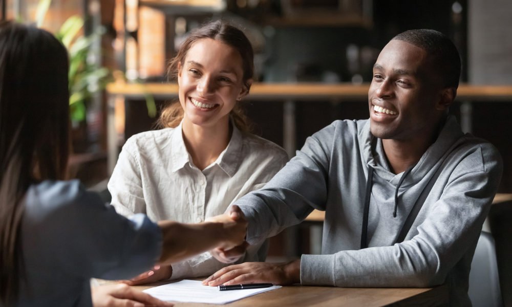 casal jovem simula o potencial de financiamento imobiliário com uma corretora