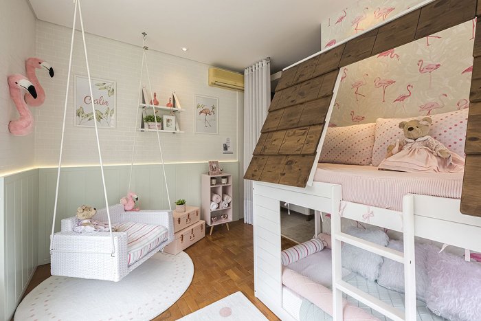 quarto infantil com detalhes em madeira e toques de rosa claro