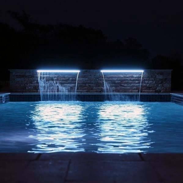 cascata iluminada sobre a piscina