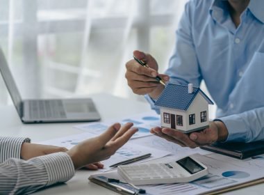 Conceito de compra de casa, corretor imobiliário com modelo de casa conversando com o cliente sobre a compra de seguro residencial e o cliente assinando contrato sob acordo formal com direito imobiliário